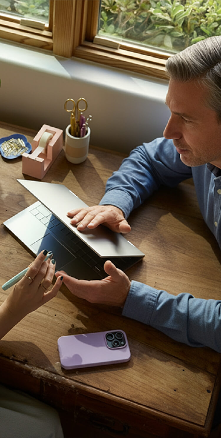 Photo of a man and woman sitting at desk and talking