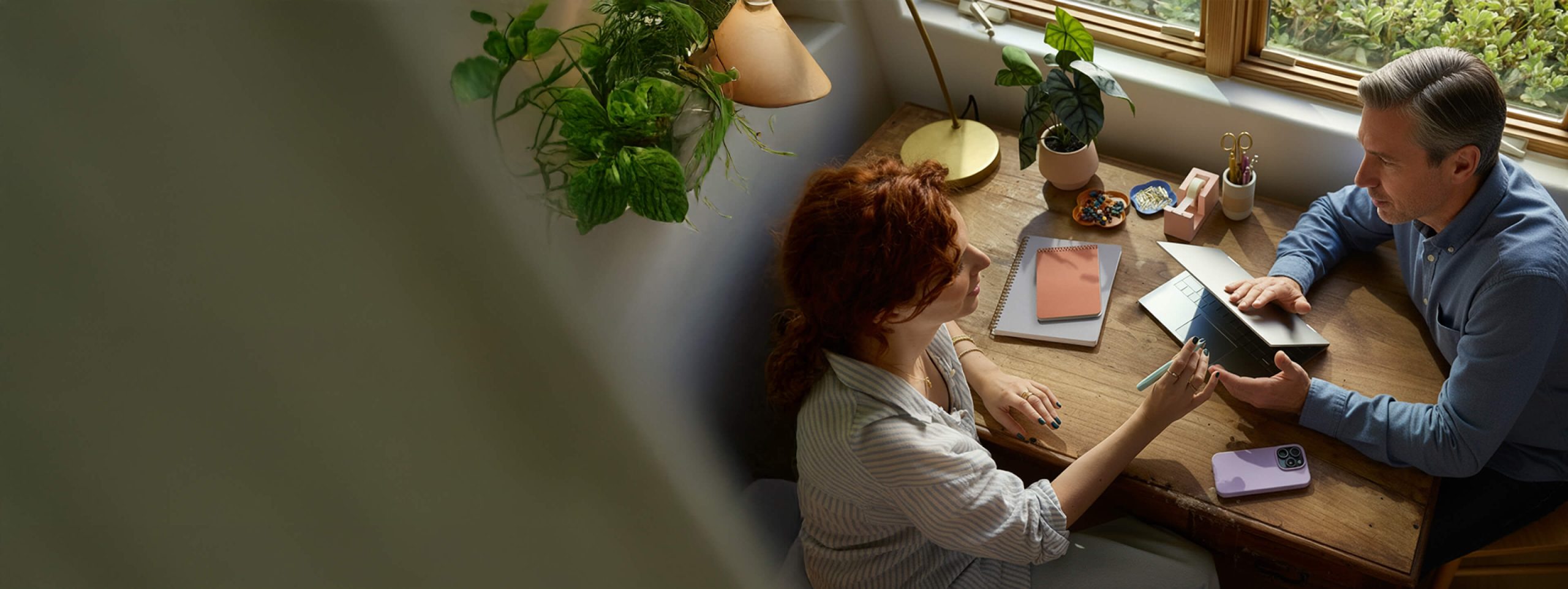 Photo of a man and woman sitting at desk and talking